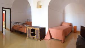 a room with a bedroom with a bed and a table at Vineyard View, Garden & Barbecue - Authentic "Dammusi" in Pantelleria