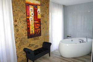 a bathroom with a bath tub and a chair at Lux'Otel City Lodge in Barcelos +28 photos