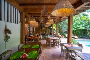 a restaurant with tables and chairs and a pool at Casa da Glória Trancoso in Trancoso