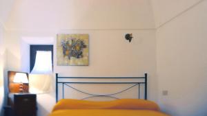 a bedroom with a bed and a painting on the wall at Vineyard View, Garden & Barbecue - Authentic "Dammusi" in Pantelleria
