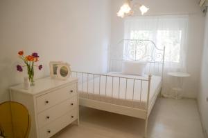 a white bedroom with a crib and a window at M&M apartment & rooms in Perast