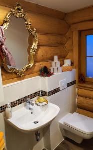 a bathroom with a white sink and a mirror at Schlossalm Ferienwohnungen in Brannenburg