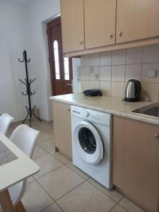 a kitchen with a washing machine in a kitchen at Sophie's Sunny Spot 2 in Yéfira
