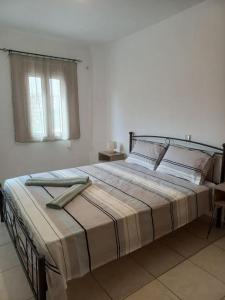 a large bed in a white room with a window at Sophie's Sunny Spot 2 in Yéfira