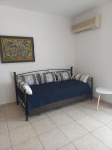 a blue bed with pillows on it in a room at Sophie's Sunny Spot 2 in Yéfira