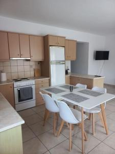 a kitchen with a white table and white appliances at Sophie's Sunny Spot 2 in Yéfira