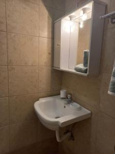 a bathroom with a white sink and a mirror at Sophie's Sunny Spot 2 in Yéfira +14 photos