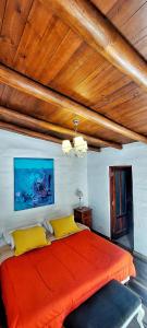 a bedroom with a large orange bed with yellow pillows at Alas del Alma in Tilcara