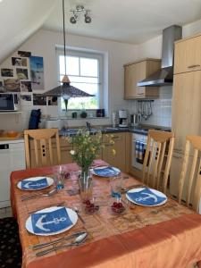 una cocina con una mesa con platos y vasos. en Sommergarten 37 C Usedom, en Ostseebad Karlshagen