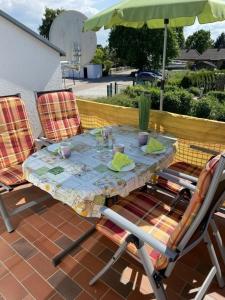 una mesa y sillas en un patio con sombrilla en Sommergarten 37 C Usedom, en Ostseebad Karlshagen