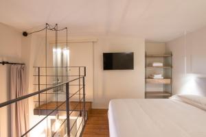 um quarto com uma cama e uma televisão na parede em Via Cerva Luxury Apartment em Milão