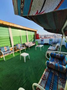 een balkon met stoelen en tafels op een schip bij Yaso Roof & Apartments in Amman