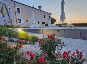 una casa con un patio con flores rojas y sombrillas en Villa Montefiore Country Resort, en Borghetto