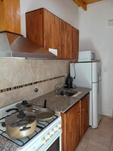 a kitchen with a stove and a white refrigerator at 4 Estaciones in Pergamino +7 photos