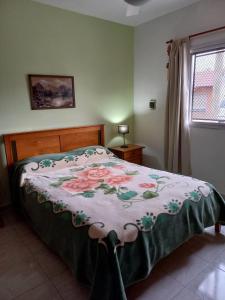 Un dormitorio con una cama con una manta de flores. en 4 Estaciones en Pergamino
