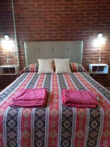 a bed with two pillows on it in a room at 4 Estaciones in Pergamino