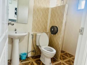 a bathroom with a toilet and a sink at เป็นต่อ รีสอร์ต in Ban Kluk Faeb