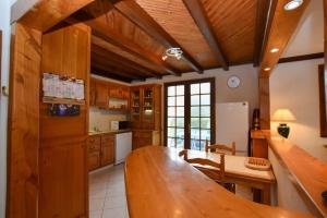 eine Küche mit einem großen Holztisch in einem Zimmer in der Unterkunft « La tranquillité » Villa avec piscine in Saint-Hilaire-de-Riez