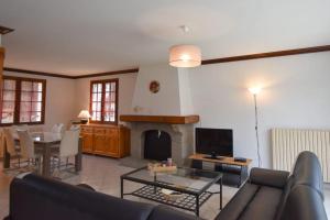 ein Wohnzimmer mit einem Sofa und einem Kamin in der Unterkunft « La tranquillité » Villa avec piscine in Saint-Hilaire-de-Riez