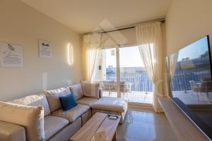 sala de estar con sofá y ventana grande en Ladybird - Veranda Sunset Retreat en Hurghada