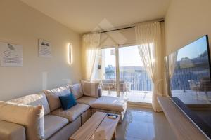 a living room with a couch and a large window at Ladybird - Veranda Highline in Hurghada