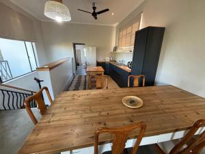 eine Küche und ein Esszimmer mit einem Holztisch und Stühlen in der Unterkunft Leopard Rock in Otjiwarongo