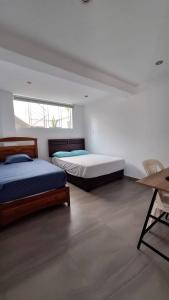 1 Schlafzimmer mit 2 Betten, einem Tisch und einem Schreibtisch in der Unterkunft Casa campo playa Puerto Viejo km 73.5 Panamericana Sur in San Andrés