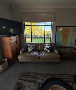 ein Wohnzimmer mit einem Sofa und einem Fenster in der Unterkunft Leopard Rock in Otjiwarongo