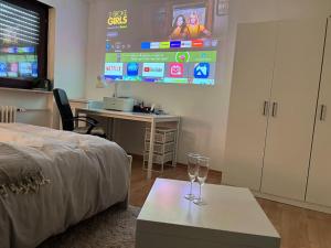 Zimmer mit einem Bett, einem Tisch und einem Bildschirm in der Unterkunft Private room with large bed -Netflix and projector in Frankfurt am Main