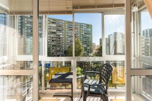 einen Balkon mit einem Tisch, Stühlen und Fenstern in der Unterkunft Nuevo Acapulco in San Francisco