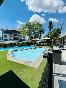 a large swimming pool in a yard with grass at Urban Oasis Retreat in Midrand