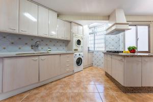 eine Küche mit weißen Schränken und einer Waschmaschine und einem Trockner in der Unterkunft Nuevo Acapulco in San Francisco