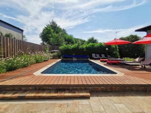 uma piscina com uma mesa e um guarda-sol em Lège-Bourg : Maison typique landaise avec piscine em Lège-Cap-Ferret