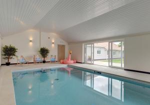 a swimming pool in a house with a large window at Wensum Retreat 