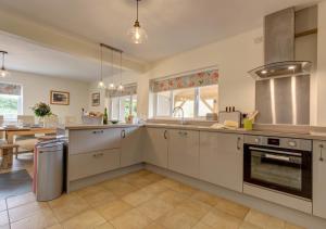 a large kitchen with white cabinets and a table at Wensum Retreat 