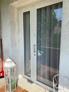 uma porta de vidro deslizante com uma lanterna ao lado em Appartamenti Villa Andrea em Garda
