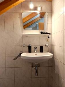 La salle de bains est pourvue d'un lavabo blanc et d'un miroir. dans l'établissement Charmante, ruhige Wohnung in Innsbruck, à Innsbruck