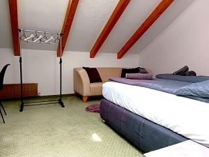 a attic room with two beds and a couch at Charmante, ruhige Wohnung in Innsbruck in Innsbruck