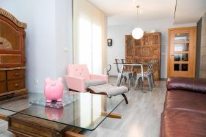 uma sala de estar com um porco rosa numa mesa de vidro em ALBOSCRIU - Duplex con piscina y barbacoa em Deltebre