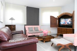uma sala de estar com um sofá de couro e uma televisão em ALBOSCRIU - Duplex con piscina y barbacoa em Deltebre