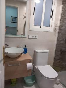 a bathroom with a toilet and a sink and a mirror at Castellón in Castellón de la Plana