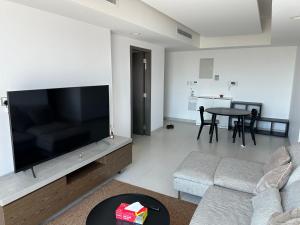 ein Wohnzimmer mit einem großen Flachbild-TV in der Unterkunft Apartment with Modern Amenities in Muscat