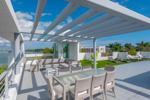 een patio met stoelen en een glazen tafel bij Indulge in Waterfront Elegance Your Ultra Luxury Miami Beach Estate Beckons! in Miami