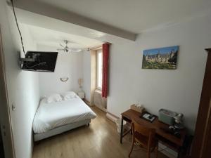 Cette petite chambre comprend un lit et un bureau. dans l'établissement Hôtel de Verdun, à Nevers