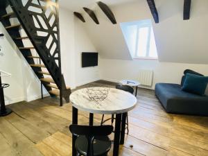 a living room with a table and a couch at Chez GABRIEL in Rodez