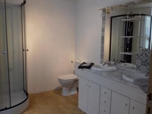 a bathroom with a toilet and two sinks and a shower at Grande maison en Aubrac in Chaudes-Aigues +7 photos