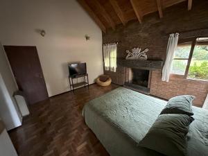 盧漢德庫約的住宿－Ruca Luma B&B - Chacras，一间卧室设有一张大床和一个壁炉