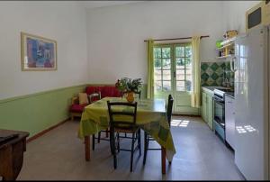 エマルグにある3 appartements pour 15 pers dans un châteauのテーブルと椅子のあるキッチンとダイニングルーム