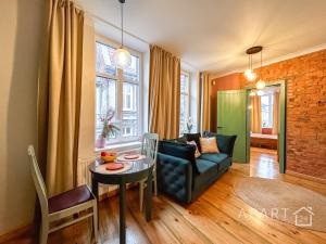 Central Old Town Apartment في غدانسك: غرفة معيشة مع أريكة وطاولة