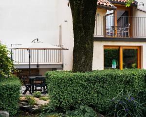 a patio with a table and an umbrella next to a building at La Casa del Ciliegio in Feltre +7 photos
